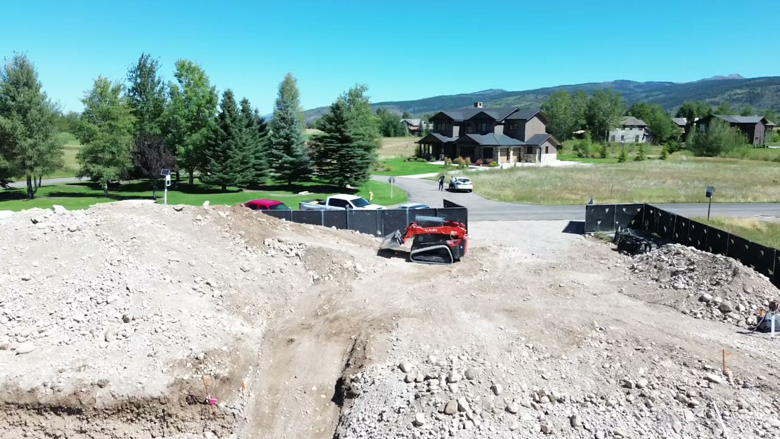 Building site cut level with trees and homes behind